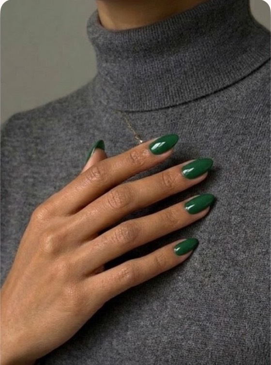 The same hand with glossy forest green nails.