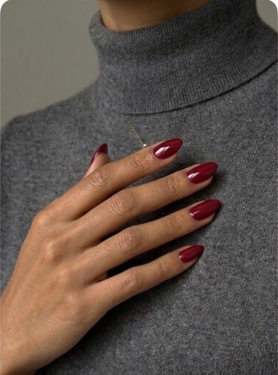 The same hand with glossy burgundy nails.